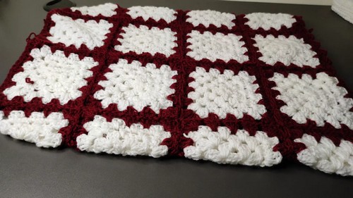 Matching granny square skirt panel laid flat in a red-and-white checkerboard layout 
