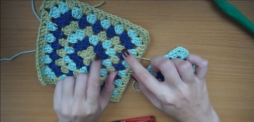 A joined block of granny squares beside a single loose square, showing the navy, lime, and aqua color layout