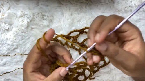 Working a row of honeycomb mesh stitches with crochet hook 