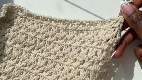 Close-up of open V-stitch crochet fabric showing the airy lace texture