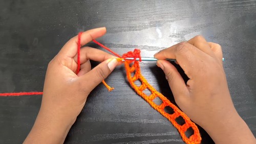 Crocheting the orange foundation row for a rainbow mesh beach skirt 