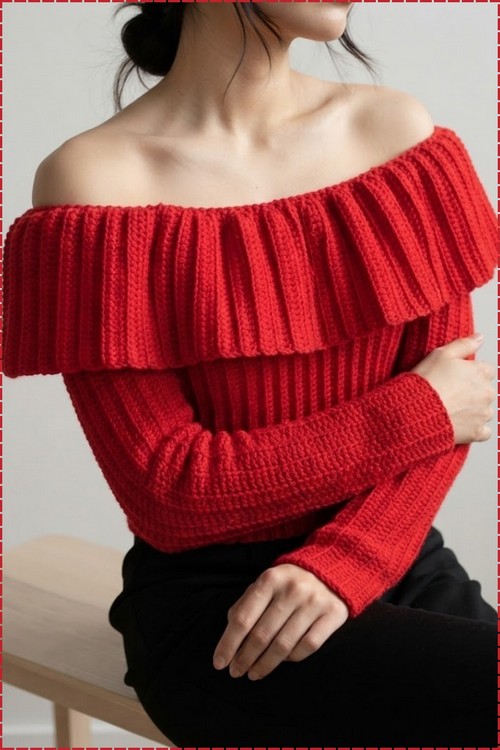 Close-up of a woman wearing the finished red crochet boat neck sweater, showing the layered ruffle collar draping across both shoulders and the ribbed stitch texture of the body and long sleeves.