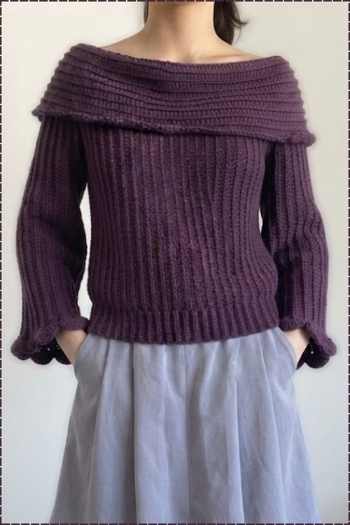 Full front view of a purple ribbed crochet sweater with an off shoulder fold-over collar and scalloped cuffs, worn over a grey skirt