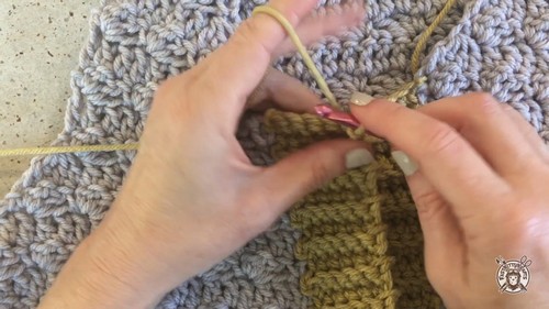 Joining the mustard yellow contrast yarn at the armhole edge to begin the colour accent trim with a stitch marker in place.