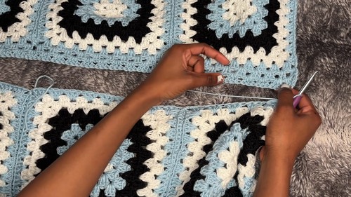 Granny squares laid flat and joined into a yoke panel with a crochet hook