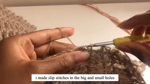 Video tutorial screenshot showing slip stitches worked through the holes of the mohair sweater fabric to cinch the waist section.