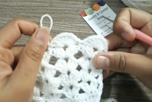 Wider section of the white crochet collar showing the shell scallops and open lace spaces taking shape