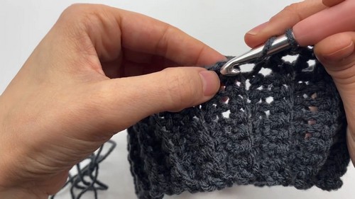 Working the ribbed grey collar of the dog sweater with a metal crochet hook